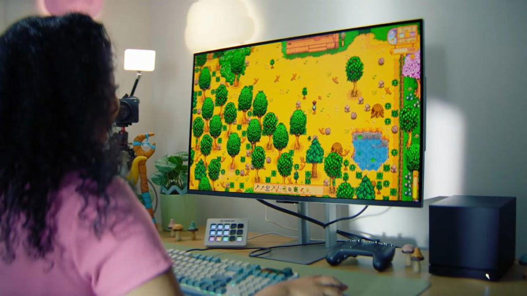 A younger gamer fully engaged with a colorful 16-Bit pixel-art game on a modern monitor